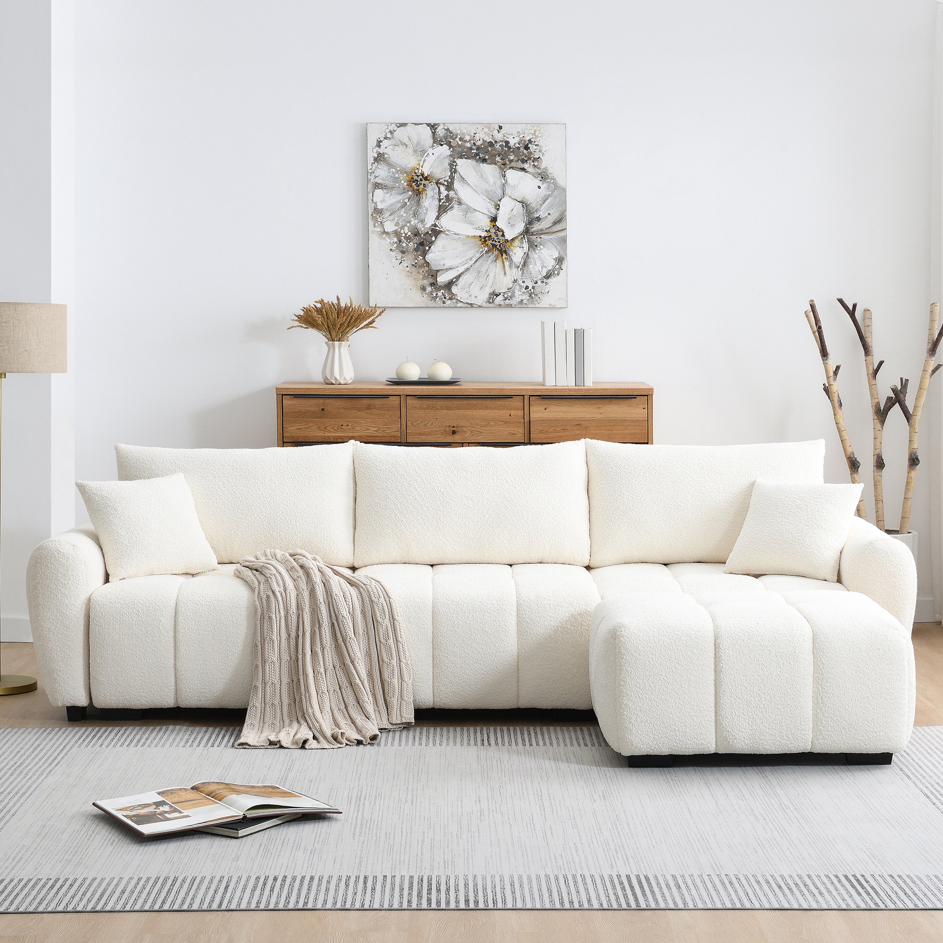 Boucle fabric modular sectional sofa with ottoman placed on the right, offering stylish and flexible seating in a cozy living space.