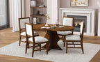 Rustic farmhouse dining set with round table and four upholstered chairs placed on a rug near a fireplace. Perfect for warm, inviting interiors.