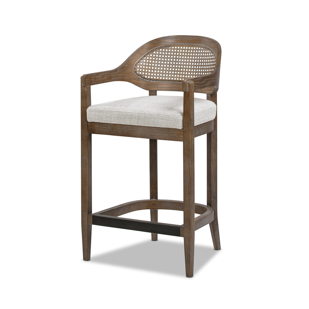 Angled view of Mid-Century Stool - Cane Back Modern highlighting wicker backrest, oak legs, and neutral cushioned seat.