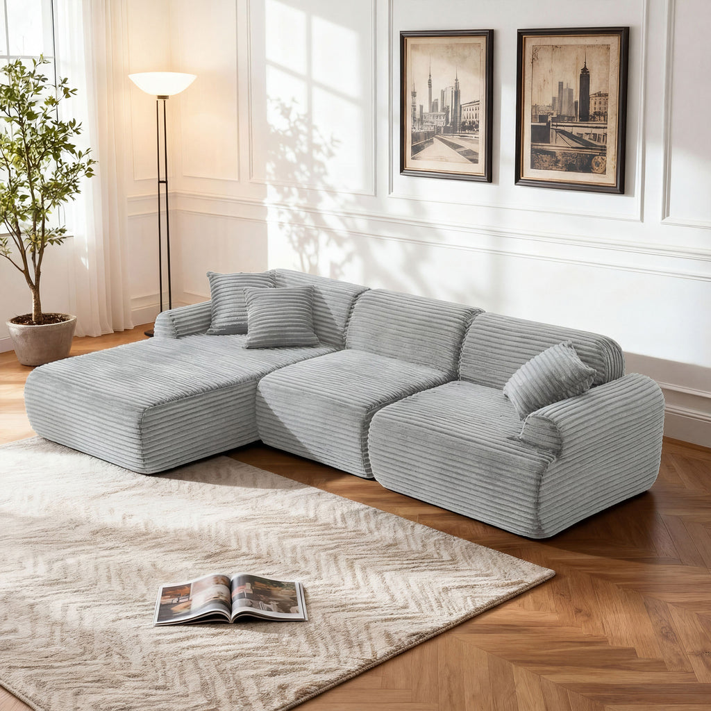 Modern light gray modular sectional sofa in textured corduroy fabric, featuring a low-profile, L-shaped lounge design.