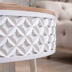 Detailed view of white carved geometric pattern on round coffee table base, paired with natural wood top.