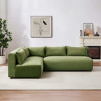 Modern modular L-shaped sectional sofa in plush green velvet, featuring low-profile, clean lines and loose cushions.