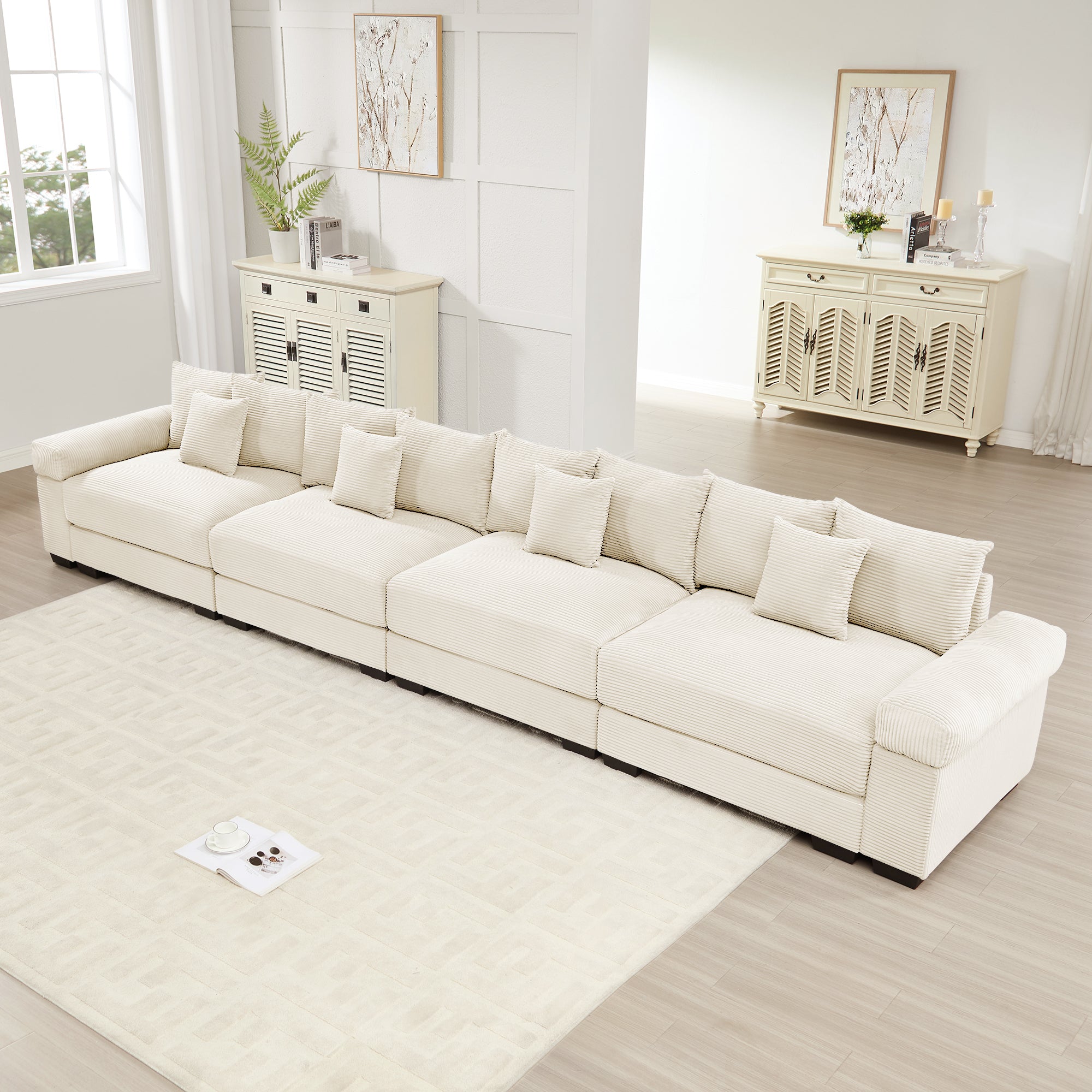 Oversized cream corduroy modular sectional sofa with thick arms and 12 throw pillows in a modern living room setting.