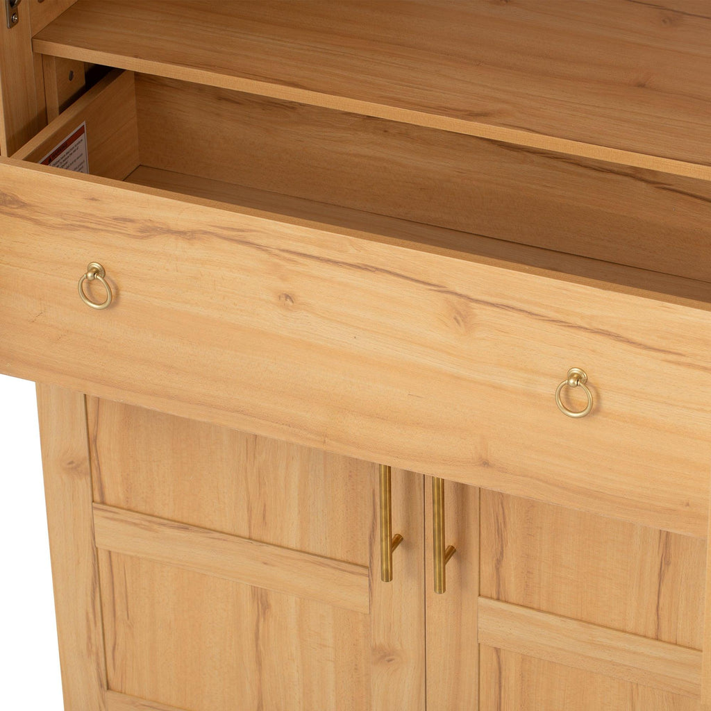 Detail view of the drawer inside the arched kitchen pantry cabinet, featuring gold ring pulls and smooth sliding mechanism.