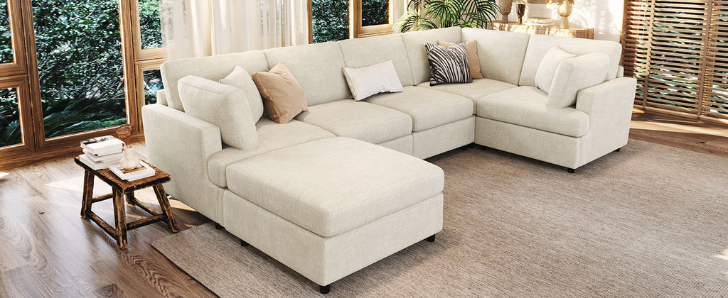 Elegant U-shaped sectional sofa with ottoman in a bright living room, offering cozy seating and modern style.