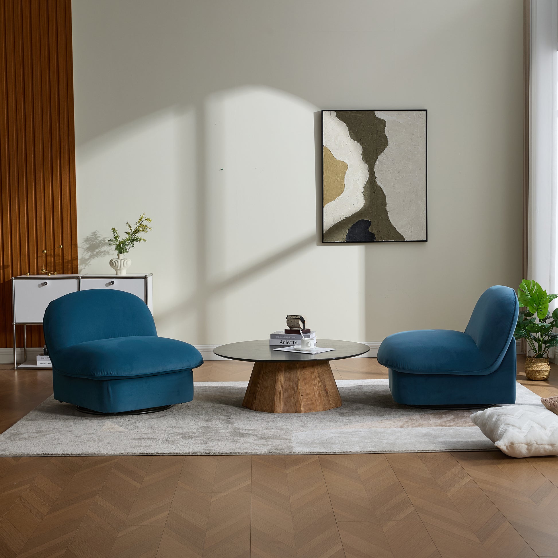 Living room scene with two velvet swivel accent chairs and a round coffee table, creating a contemporary and inviting space.