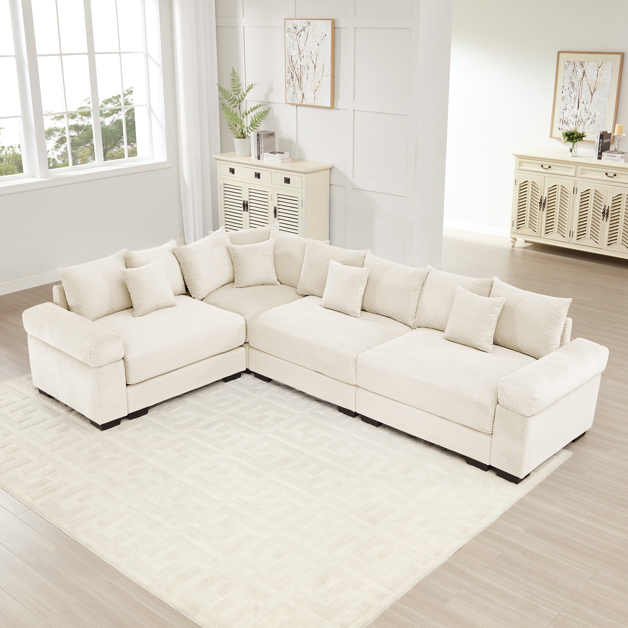 Oversized cream corduroy modular sectional sofa with deep seats, extra-wide armrests, and twelve matching throw pillows.