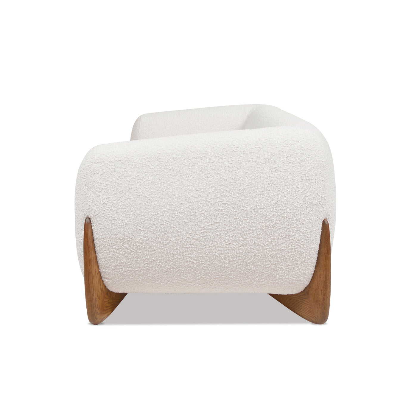 Side profile of Alpine Sherpa Sofa Ivory White displaying curved armrest and oak wood leg for a sculptural furniture silhouette.