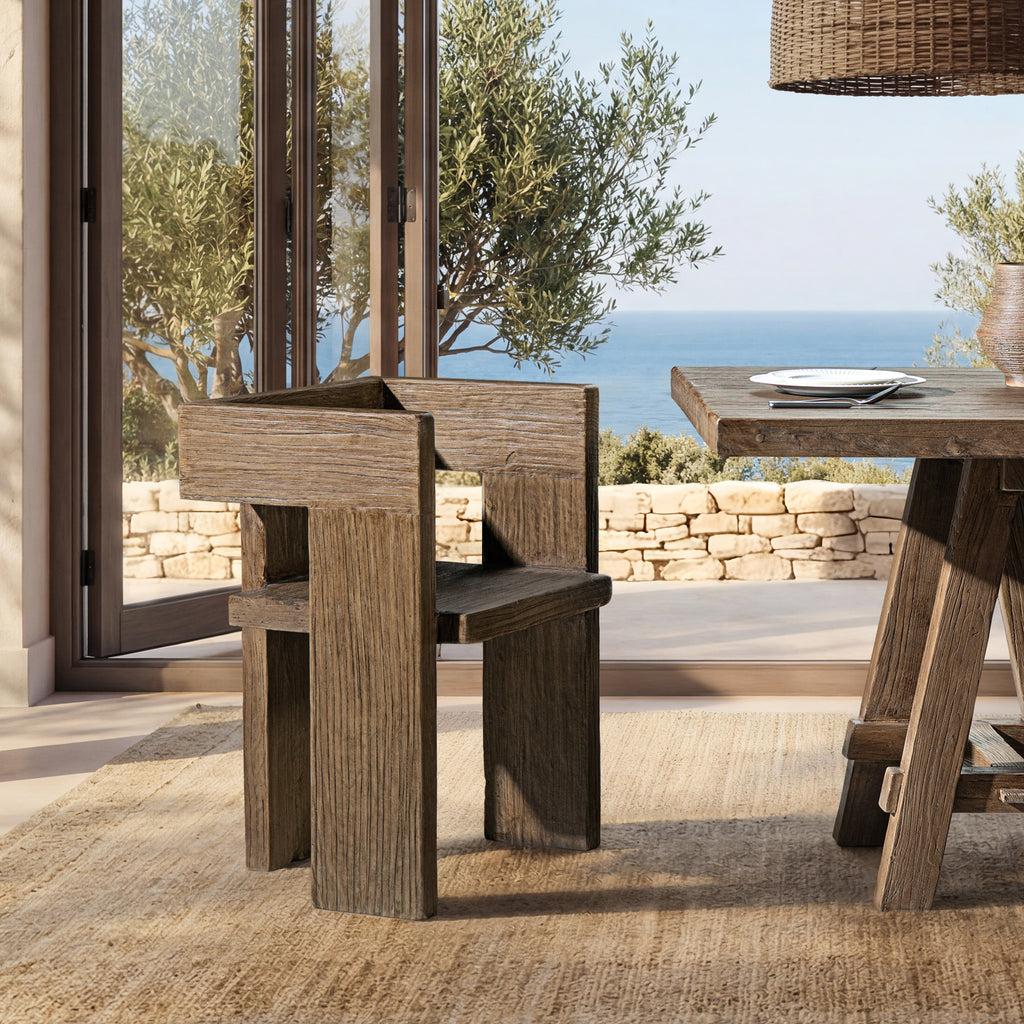 Sculptural accent chair made of medium-dark brown reclaimed elm, featuring a minimalist block design and wood grain.