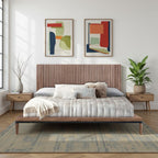 Walnut Finish Queen Size Platform Bed with vertical slat headboard, styled in a bright room with modern art and indoor plants.