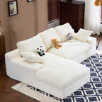 Side angle of White Corduroy Sofa showing soft corduroy texture, 3 back cushions, and 2 pillows on a blue patterned rug.