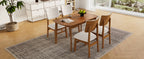 Top-down view of farmhouse dining table set for 4, highlighting wood tabletop and cushioned chairs in a cozy dining room.