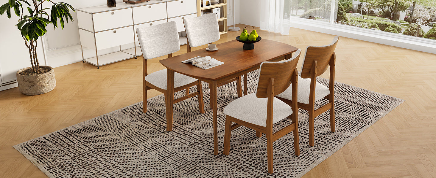 Top-down view of farmhouse dining table set for 4, highlighting wood tabletop and cushioned chairs in a cozy dining room.