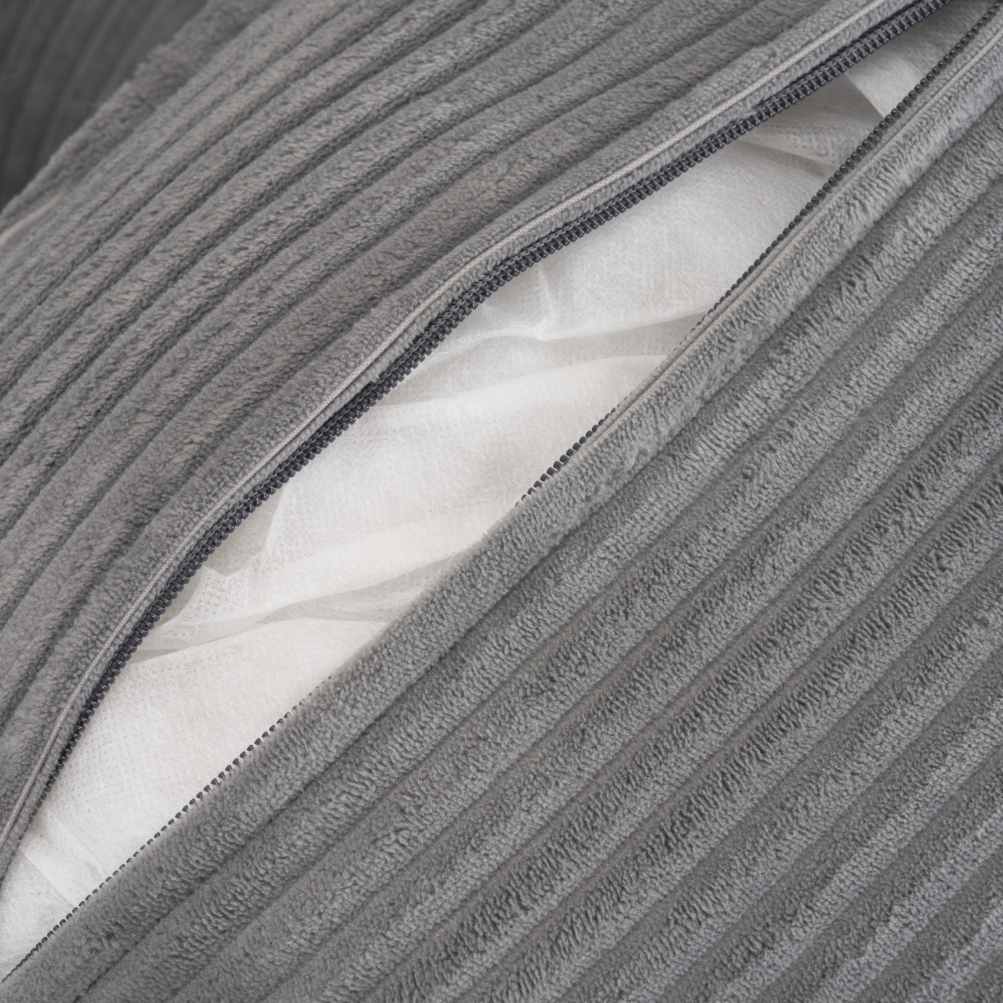 Zippered cushion cover on modular sofa revealing inner padding, designed for easy cleaning and long-lasting comfort.