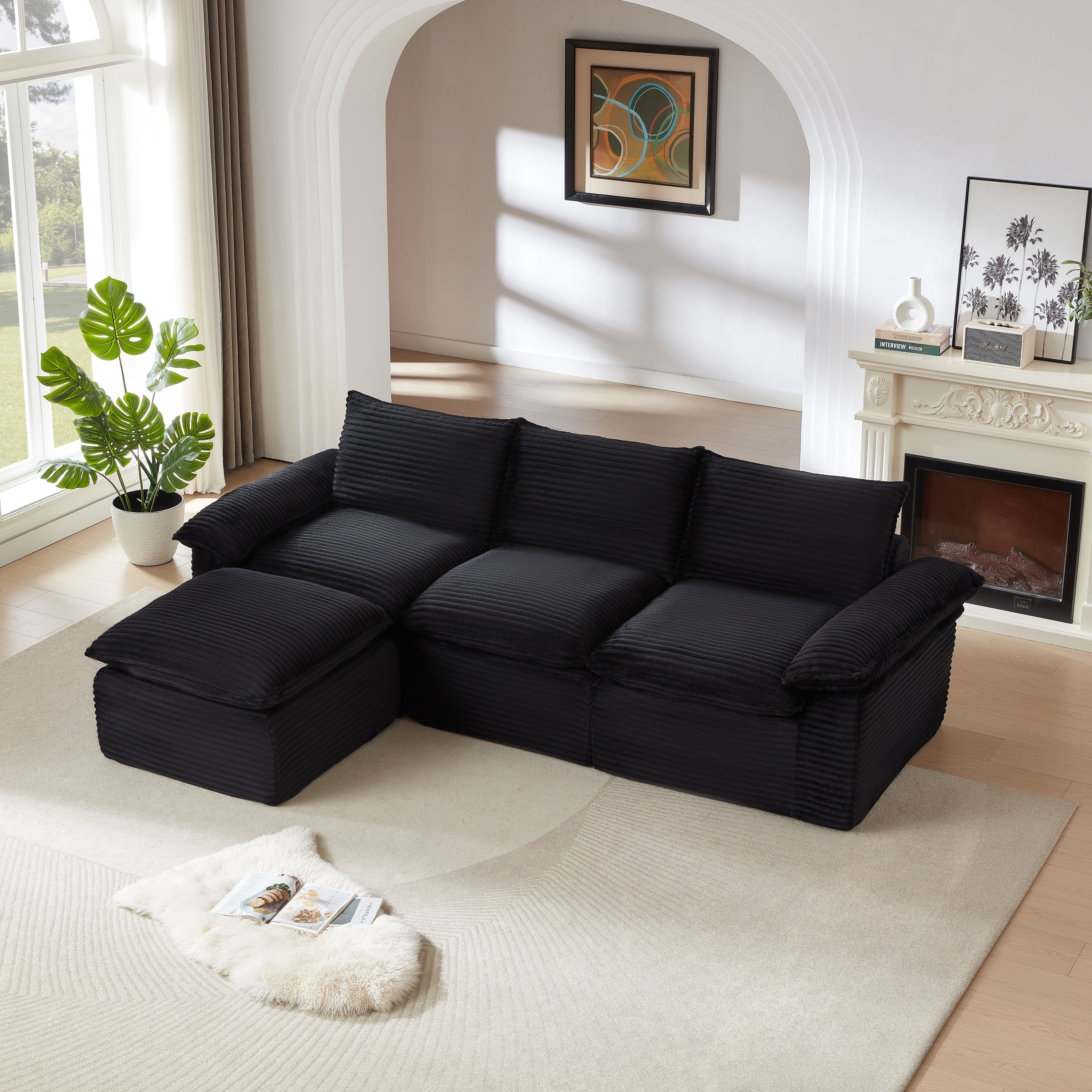 Three-seat modular corduroy sofa in black with chaise, placed in a bright modern living room. Perfect for stylish and adaptable home decor.