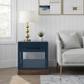 Nora 22 Inch End Table with Drawer and Shelf in Blue Denim and Whiskey finish beside a sofa, ideal for modern living rooms, no assembly required.