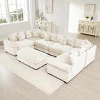 Oversized cream corduroy modular sectional sofa with wide armrests and a matching ottoman in a bright living room.