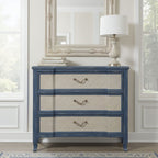 Three-drawer bachelor chest in serene ocean blue with textured beige drawer fronts and antique brass pull handles.