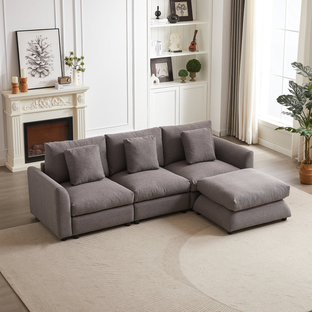 Modular sofa with ottoman in gray upholstery, arranged in L-shape in a modern living room with fireplace and bookshelf decor.