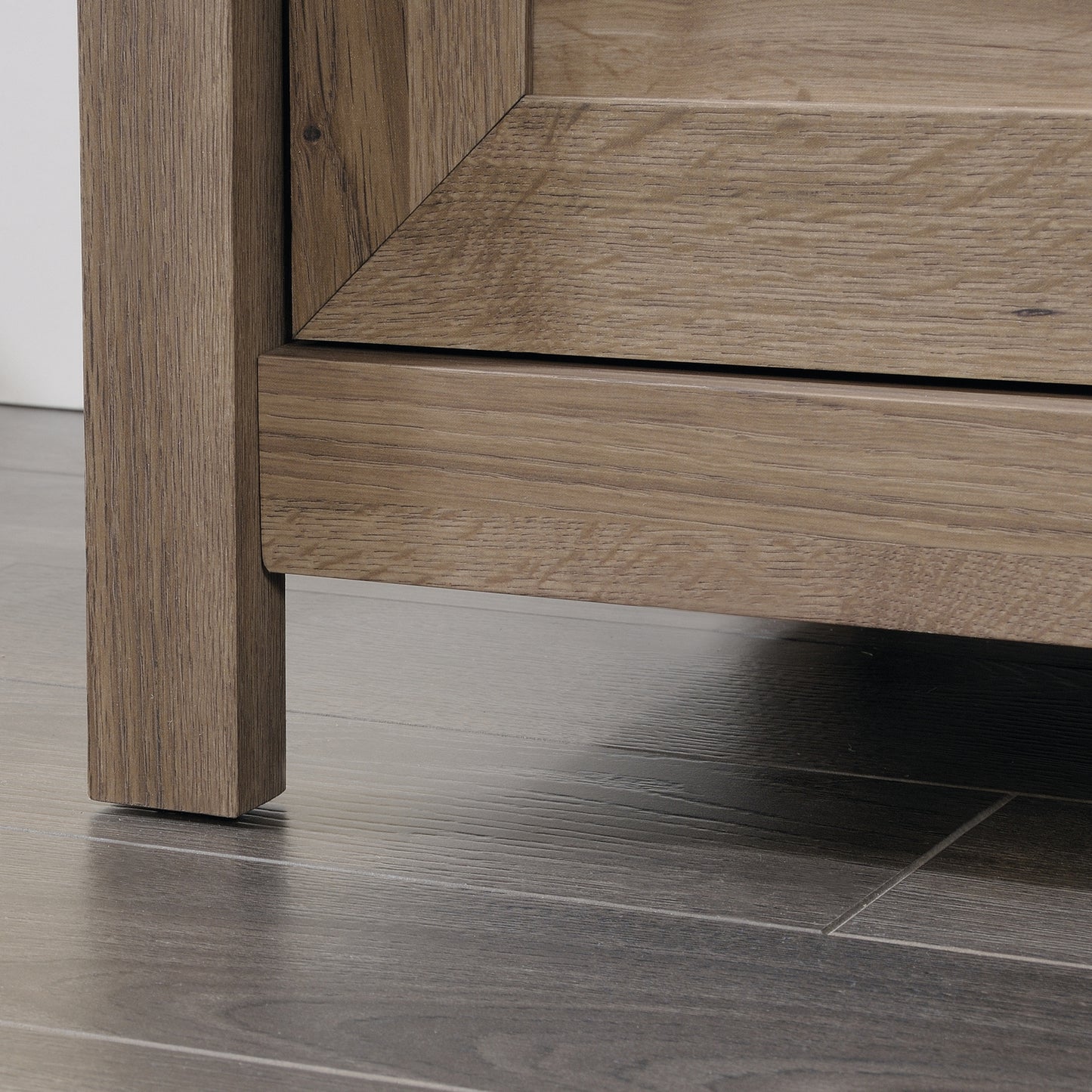 Bottom corner of the brown dresser showing sturdy leg construction and wood texture, suitable for bedroom storage.