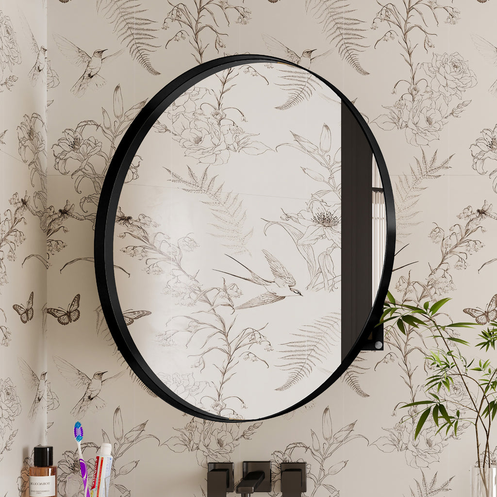 Round Black Metal Medicine Cabinet with Mirror closed, reflecting floral wallpaper in a stylish bathroom setting.