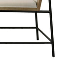 Leg and frame detail of Bowen Oak Dining Set chair. Black metal base supports cream cushion and oak frame.