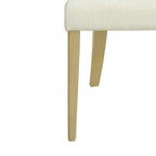 Close-up of the leg and seat corner of a contemporary dining chair, showing the light ash wood finish and beige fabric texture.