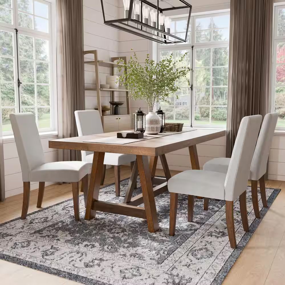 Rustic dining room setup featuring six white upholstered chairs with brown wood legs around a wooden table, cozy and stylish decor.