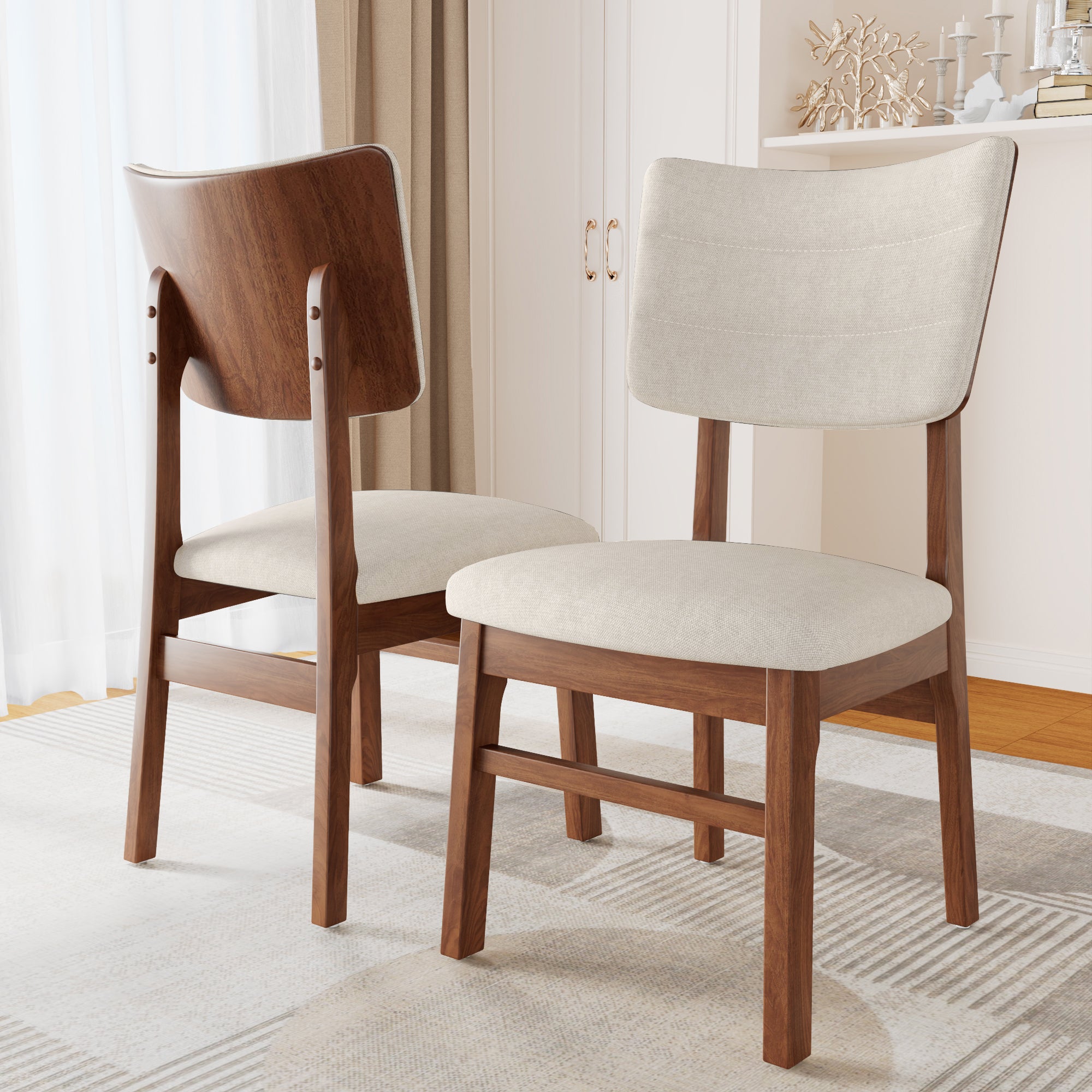 Pair of Mid-Century Modern Dining Chairs featuring curved wooden backs and cushioned beige seats on a light area rug.