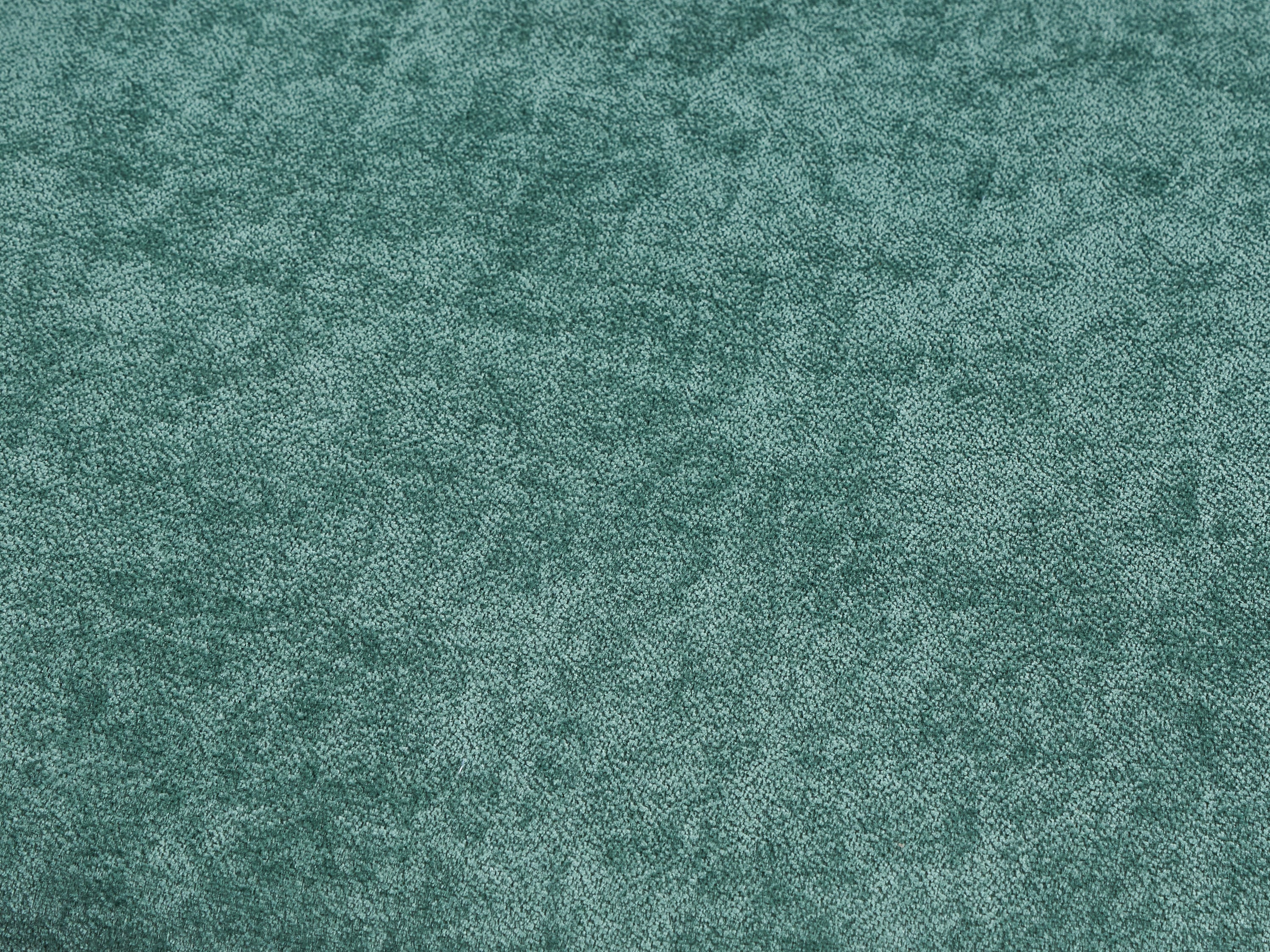 Close-up texture of green upholstery fabric used on chairs in the walnut dining set, offering a soft and stylish seating experience.