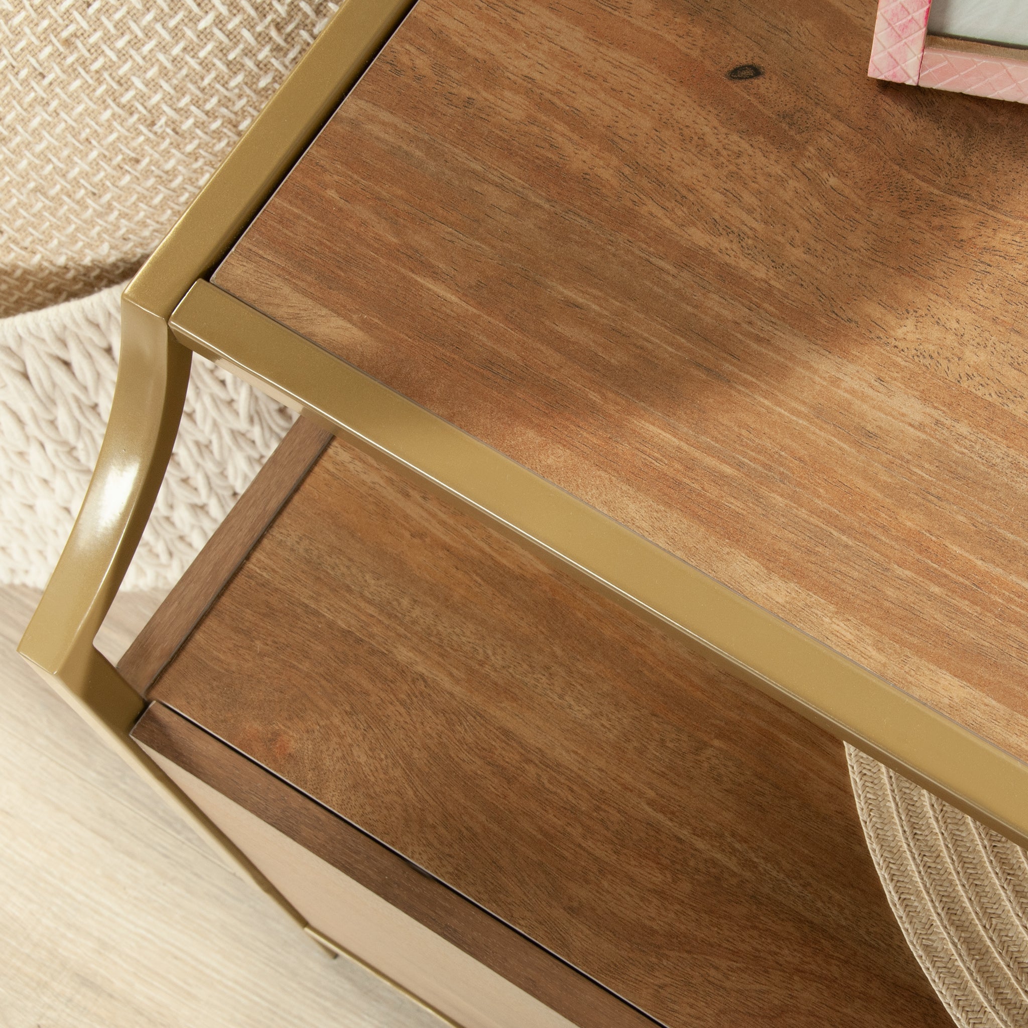 Top corner view of brown dresser furniture for bedroom with gold metal trim and wood grain finish.