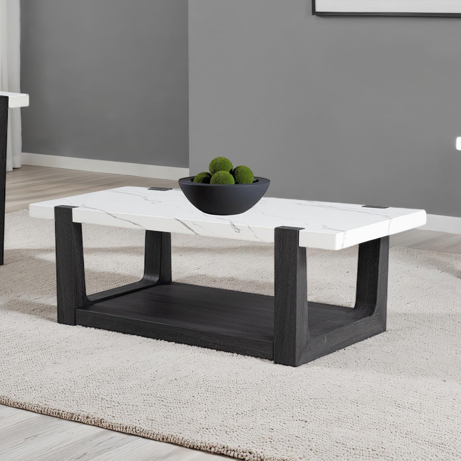 Stylish modern coffee table faux marble with black base and white top, enhancing a minimalist living room interior.