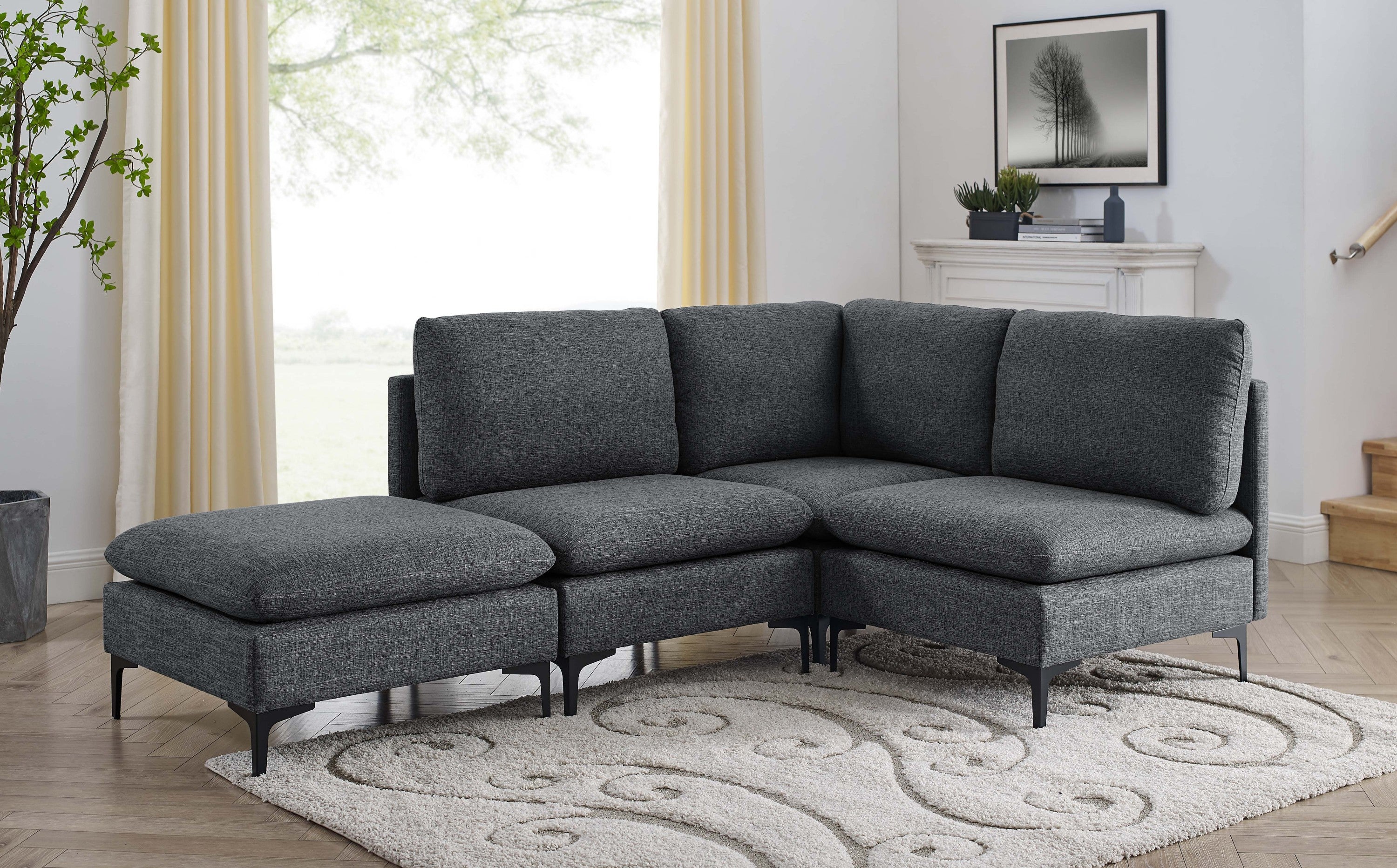 Dark gray linen modular sectional sofa with plush cushions and sleek black metal legs on a patterned area rug.