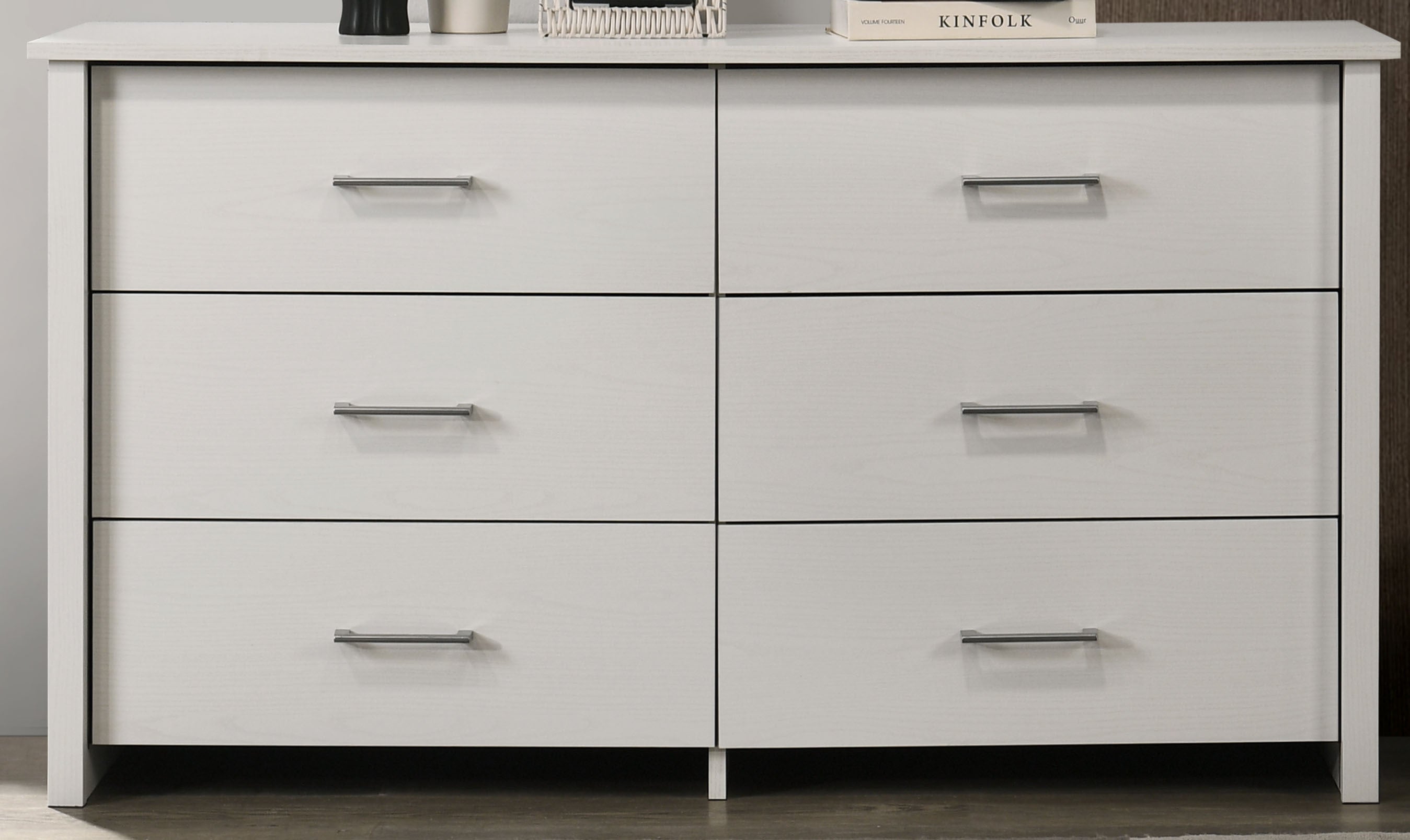 Close-up front view of white 6-drawer dresser with sleek silver handles. Ideal for organizing bedroom essentials with a modern touch.