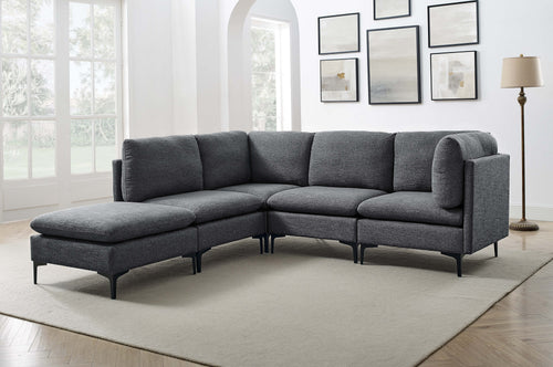 Modern charcoal grey linen modular sectional sofa with plush cushions and slim black metal legs in a bright living room.