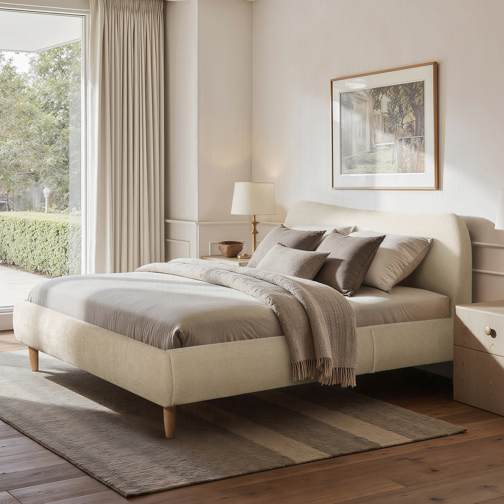 Beige Upholstered Platform Bed with Curved Headboard in a modern bedroom, featuring neutral bedding and wood flooring for a serene look.