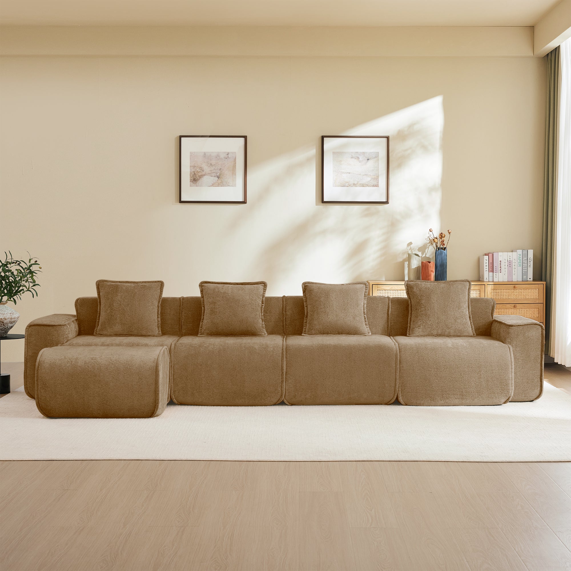 Velvet brown 4-seater modular L shape sofa with French piping, shown against a neutral wall with framed art and wooden furniture.