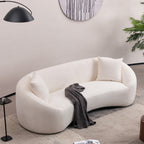 Angled overhead view of minimalist white curved sofa in a stylish living room with cozy decor elements.