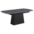 Modern dining table with black faux marble top, extension leaf, and a sleek, black tapered metal pedestal base.