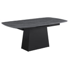 Modern dining table with black faux marble top, extension leaf, and a sleek, black tapered metal pedestal base.