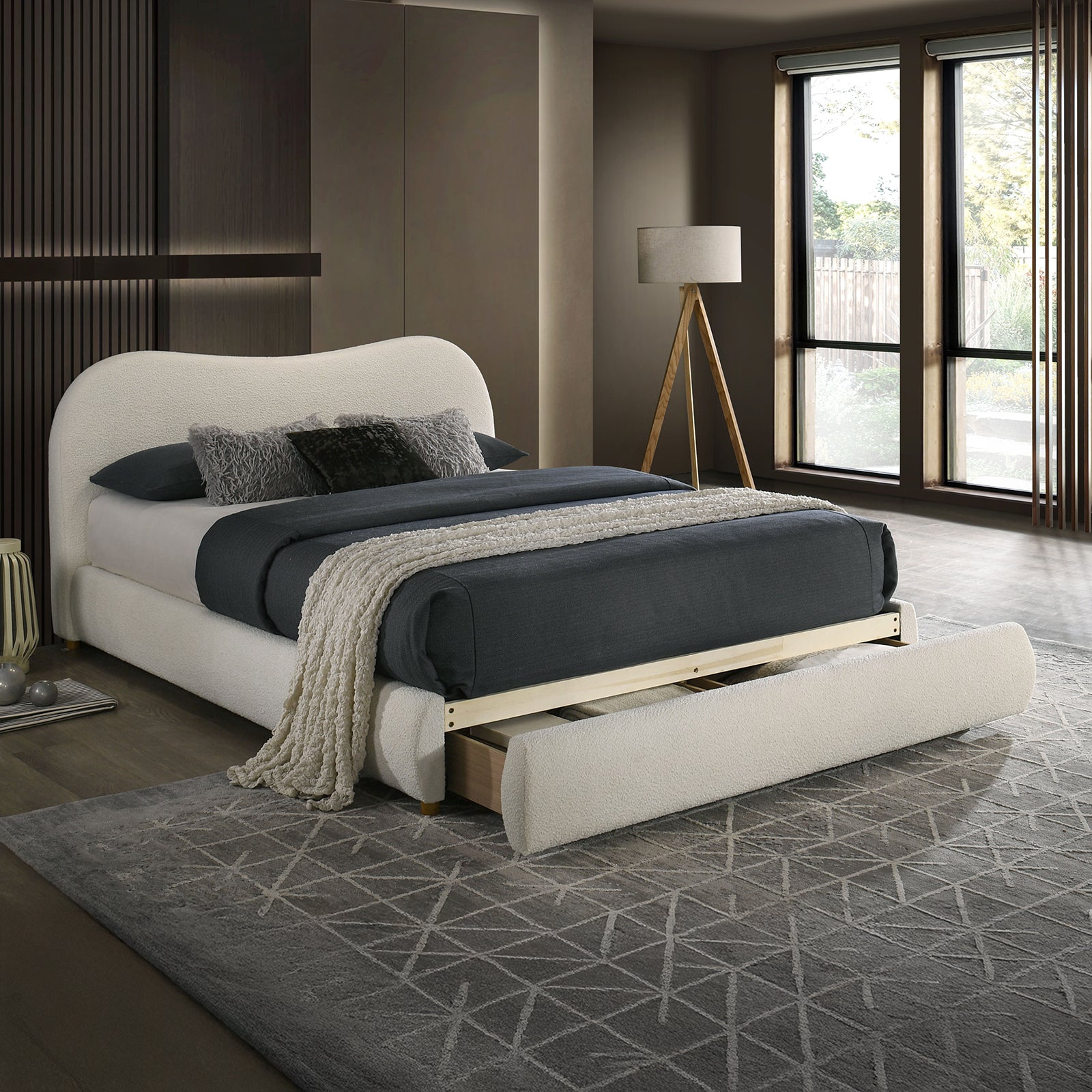 Velvet King Size Bed with curved headboard and open footboard drawer, styled in a modern bedroom with natural light and neutral tones.