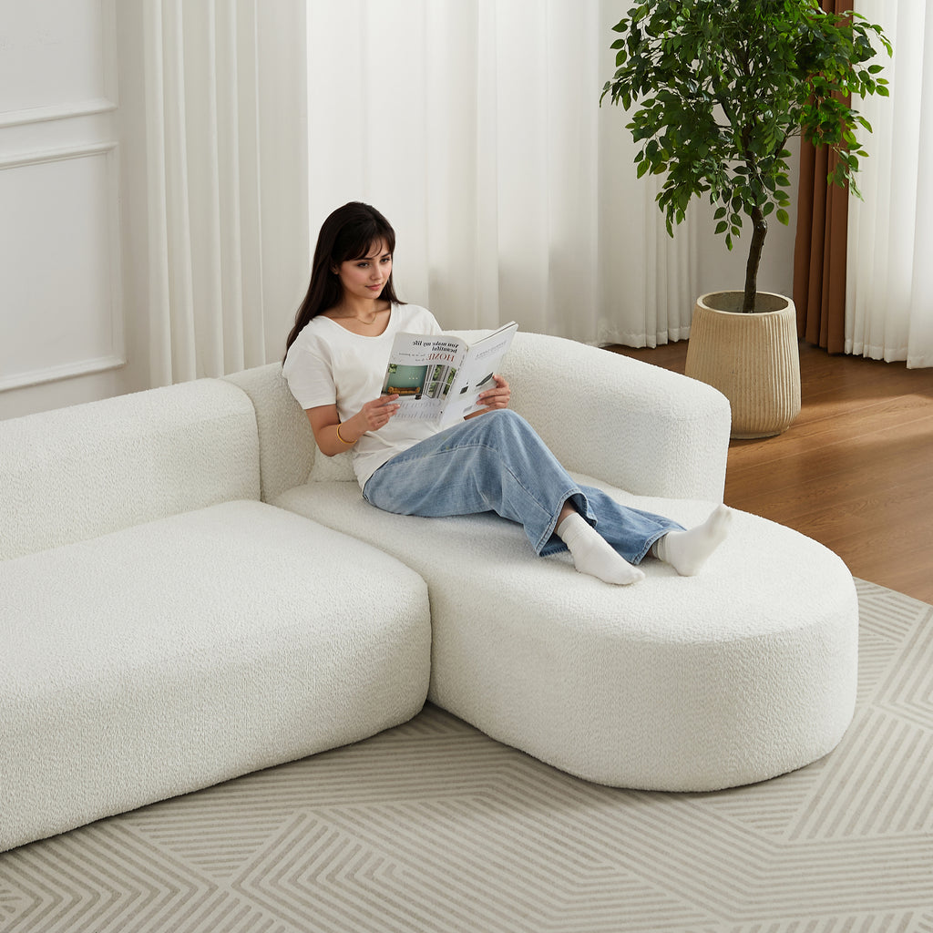 Woman lounging on 109.4' modular sectional sofa in beige chenille fabric, showcasing its spacious and comfortable seating.