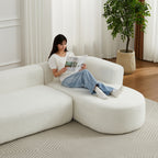 Woman lounging on 109.4' modular sectional sofa in beige chenille fabric, showcasing its spacious and comfortable seating.
