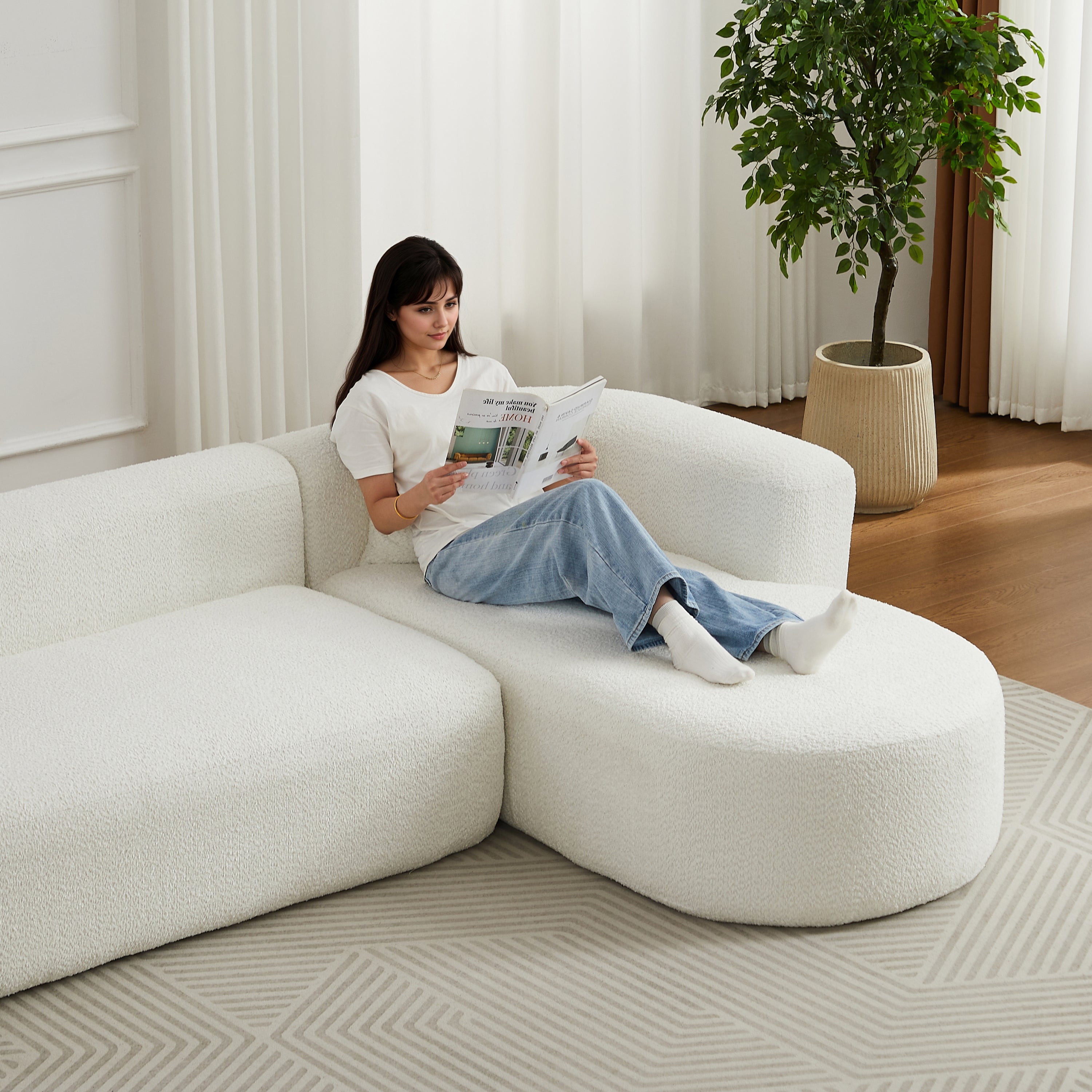Woman lounging on 109.4' modular sectional sofa in beige chenille fabric, showcasing its spacious and comfortable seating.