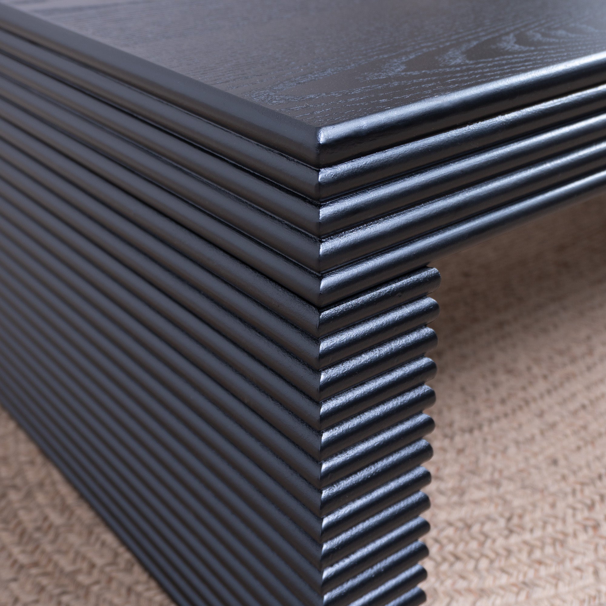 Close-up of ribbed leg detailing on 47.6 modern black coffee table, emphasizing its textured craftsmanship and modern design.