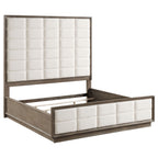 Eastern king panel bed in taupe oak with cream fabric, featuring a tall headboard and footboard with grid tufting.