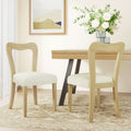 Contemporary dining chairs set of 2 in light ash and beige placed in a modern dining room with wood table and floral decor.