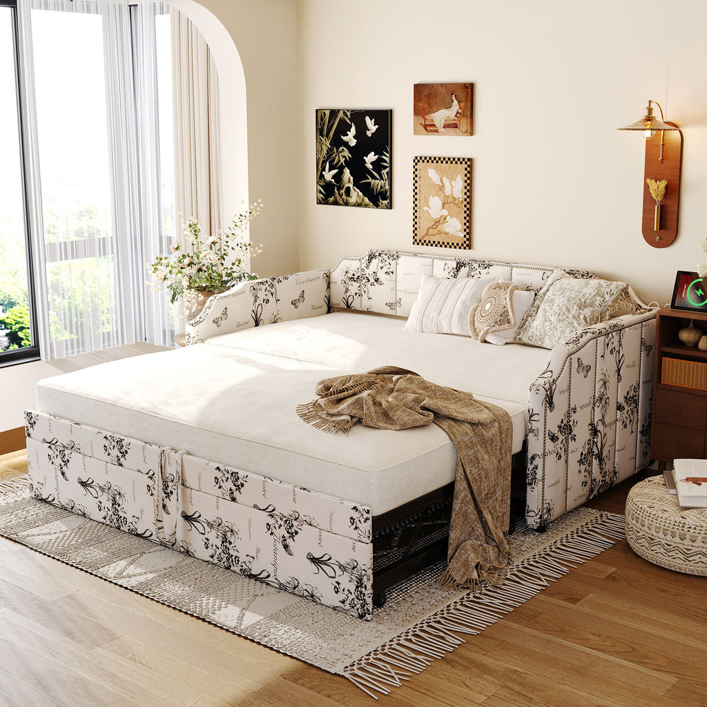 Upholstered twin daybed featuring a black-and-white botanical print, pop-up trundle, and integrated USB charging ports.
