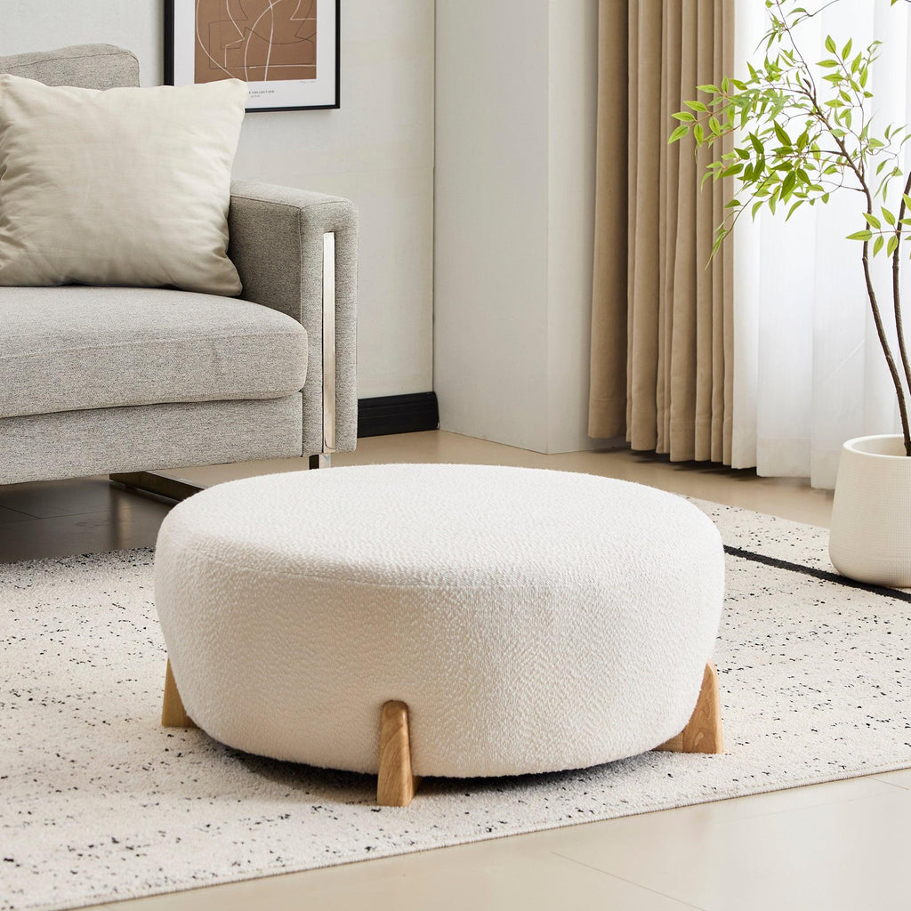 Modish Round Ottoman with Boucle Top and Natural Wood Legs.