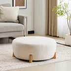 Modish Round Ottoman with Boucle Top and Natural Wood Legs.